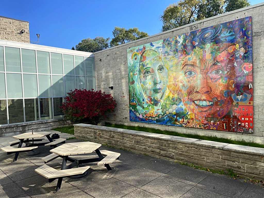 A large portrait mural installed on an exterior wall at Brescia University in London, Ontario