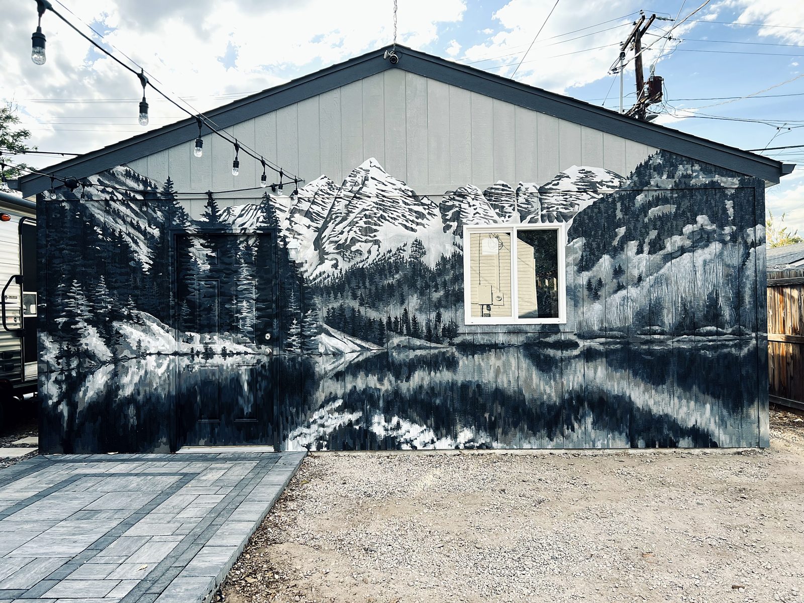 A monochrome mountain and lake mural wrapping the exterior of a building