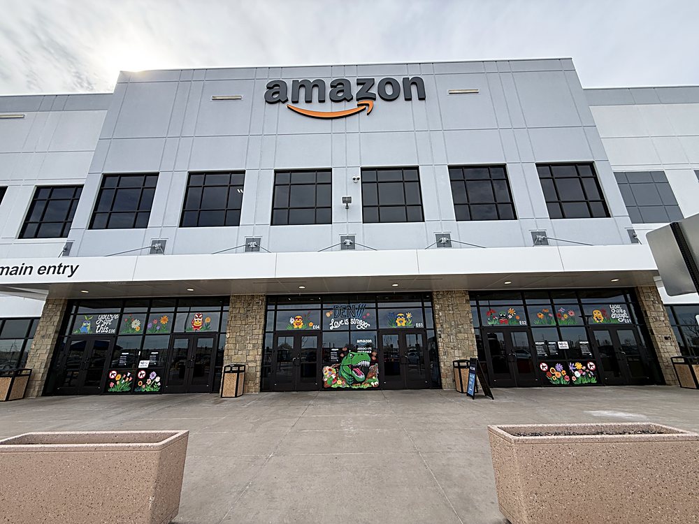 Hand-painted seasonal window display on the entrance glazing of an Amazon fulfillment center in Colorado, march 2026. the main entry on the approach